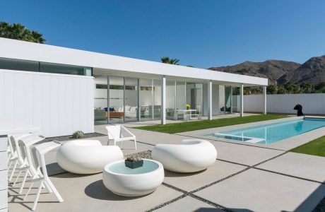 A sleek, modern home with a minimalist patio, pool, and mountain backdrop.