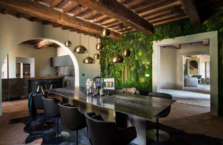 Rustic wooden beams, sleek modern furnishings, and a stunning moss-covered feature wall create a stunning interior space.