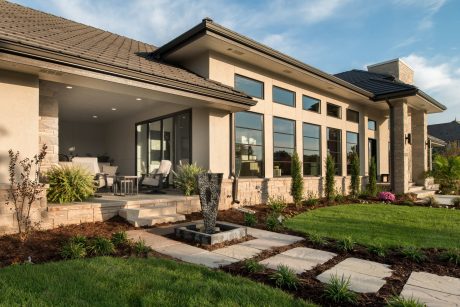 Beautiful contemporary home with stone exterior, large windows, and an inviting outdoor patio.