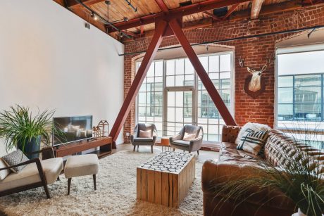 Rustic industrial loft with exposed brick, wooden beams, and modern furnishings.