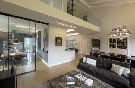 Spacious open-concept living area with sleek, modern furnishings and lighting fixtures.