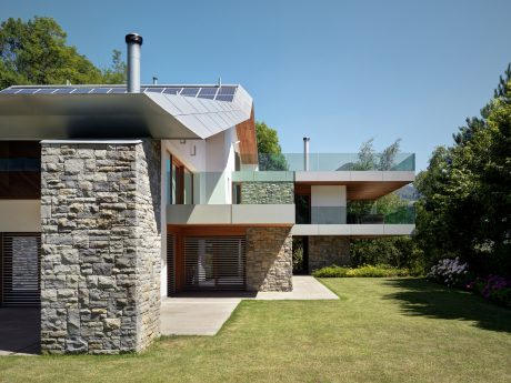 A modern, energy-efficient home with a mix of stone, wood, and glass elements.