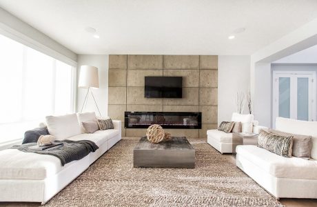 Spacious living room with a concrete panel accent wall, recessed lighting, and a large, plush sectional sofa.