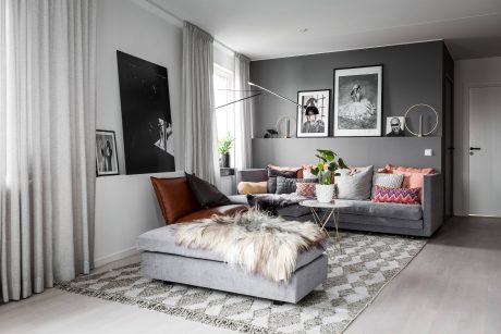 A stylishly decorated living room with modern gray furniture, artwork, and textured accents.