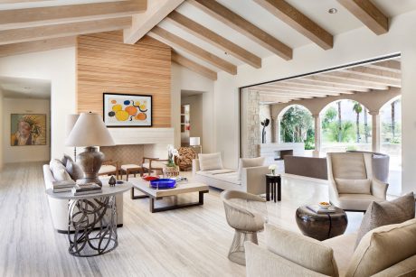 Bright, open-concept living space with wood-beamed ceiling, stone arches, and modern furnishings.