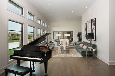 Spacious living room with grand piano, large windows, and modern furniture design.