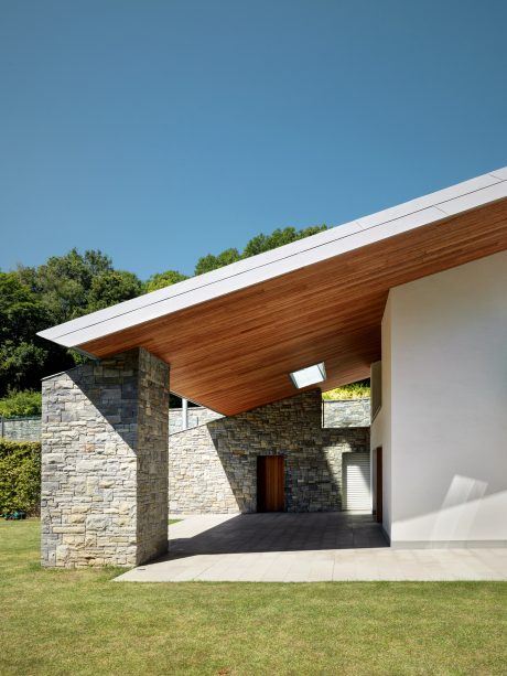 Striking architectural design featuring stone walls, wooden roofing, and expansive glass windows.