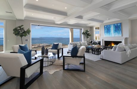 Spacious living room with panoramic ocean view, modern furniture, and vibrant artwork.