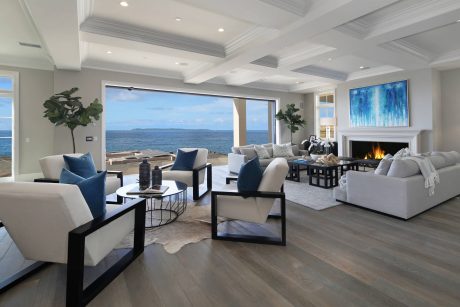 Spacious living room with panoramic ocean view, modern furniture, and vibrant artwork.