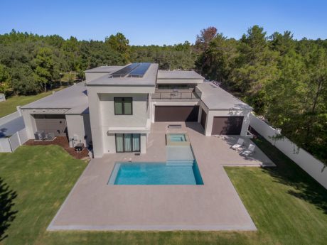 Modern two-story home with solar panels, private pool, and lush landscaping.