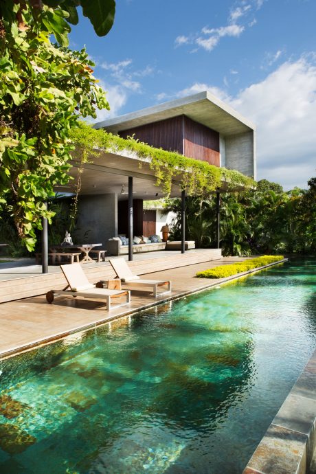 A modern, nature-inspired villa with a sleek, cantilevered roof and an inviting infinity pool.