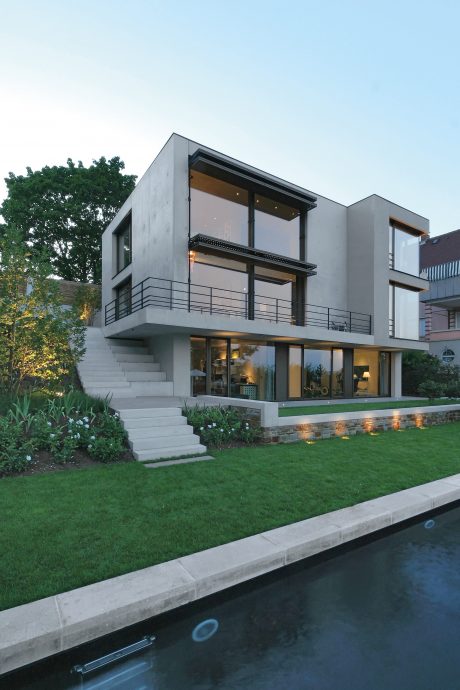 Striking modern home with sleek facades, generous balconies, and a tranquil reflecting pool.