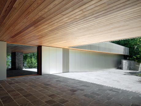 A modern building with a wooden ceiling, stone walls, and a large open space with a paved floor.