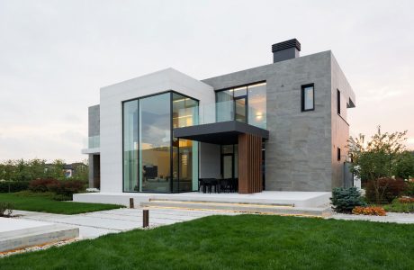 Sleek, modern design with glass walls, wooden accents, and an elevated entryway.