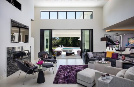 Stunning open-concept living room with high ceilings, large windows, and modern furnishings.