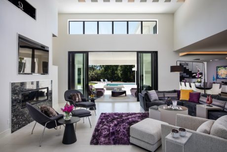 Stunning open-concept living room with high ceilings, large windows, and modern furnishings.