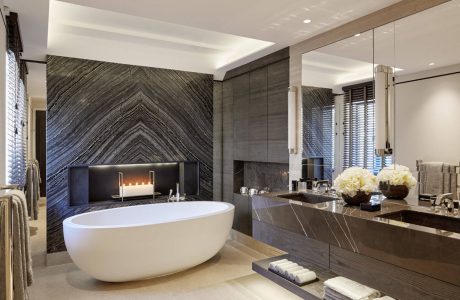 Luxurious bathroom with sleek marble walls, freestanding tub, and modern vanity.