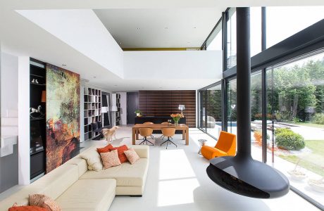 A modern open-concept living space with large windows, sleek furniture, and vibrant accents.