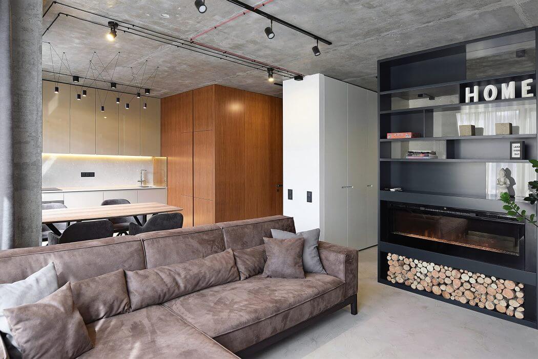 Minimalist concrete loft with wooden cabinetry, cozy sofa, fireplace, and industrial lighting.