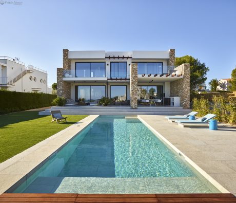 Contemporary architectural masterpiece with a sleek, minimalist design, inviting pool, and lush landscaping.