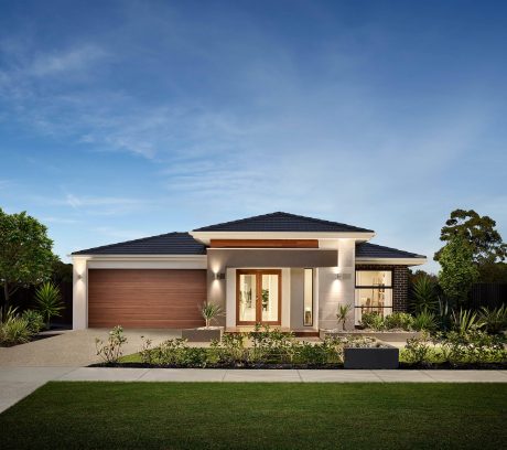 Modern single-story home with clean lines, tiled roof, and lush landscaping.