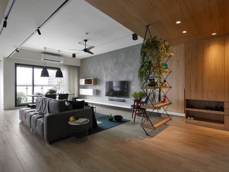 Expansive living room with modern wood paneling, built-in shelves, and lush greenery.