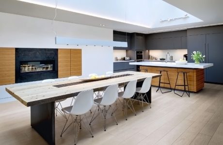 Spacious open-plan kitchen with large wooden dining table, modern appliances, and sleek cabinetry.