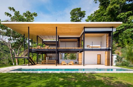 Modern tropical retreat with timber and steel frame, swimming pool, and lush greenery.