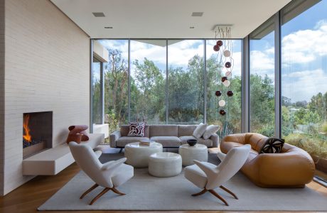 Elegant modern living room with floor-to-ceiling windows, fireplace, and sculptural lighting.