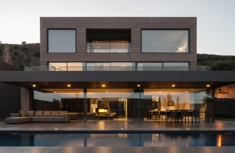 Sleek, modern architecture with open interior spaces, glass walls, and a reflection pool.