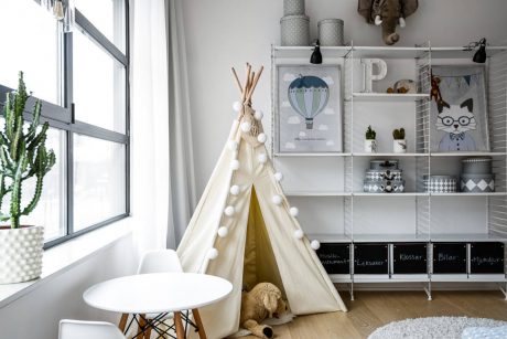 Cozy child's room with teepee tent, shelving unit, and decorative accents.