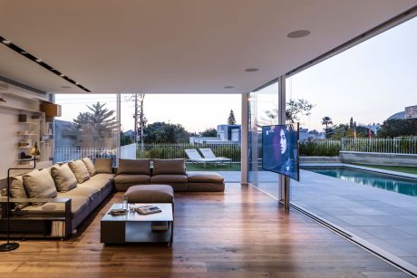 Spacious open-concept living area with floor-to-ceiling windows overlooking lush outdoor area.