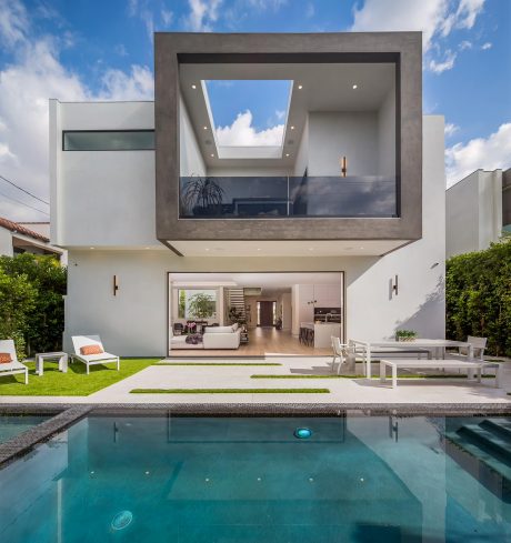 A modern, two-story house with a large skylight, open-plan interior, and swimming pool.