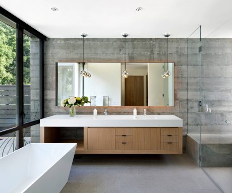 Sleek concrete walls, floating vanity, and pendant lights create a modern bathroom design.