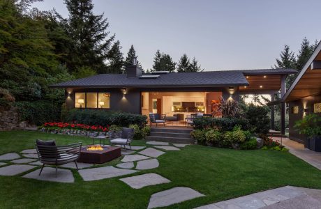 Elegant modern home with expansive patio, stone pathways, and lush landscaping.