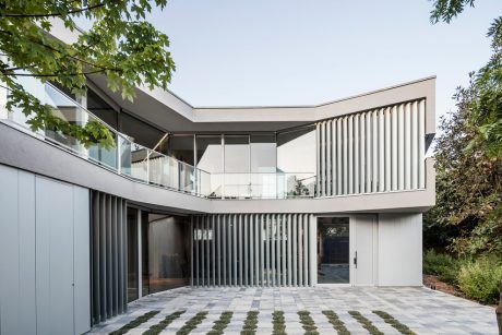 A modern, angular building with extensive glass walls, balconies, and a sleek, angular facade.