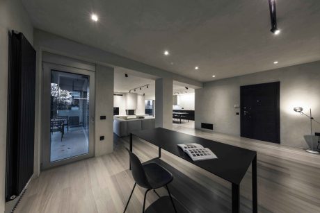 Sleek, modern interior with minimalist furniture, track lighting, and large windows.