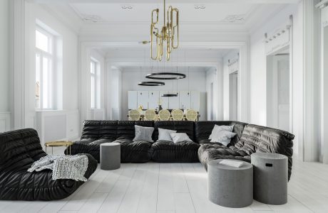 A spacious, modern living room with plush, black sectional sofas and a grand brass chandelier.