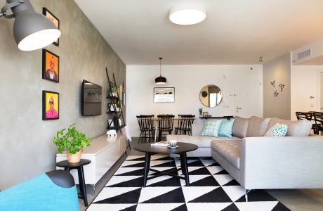 Spacious, contemporary living room with minimalist decor, modern furnishings, and unique patterned flooring.