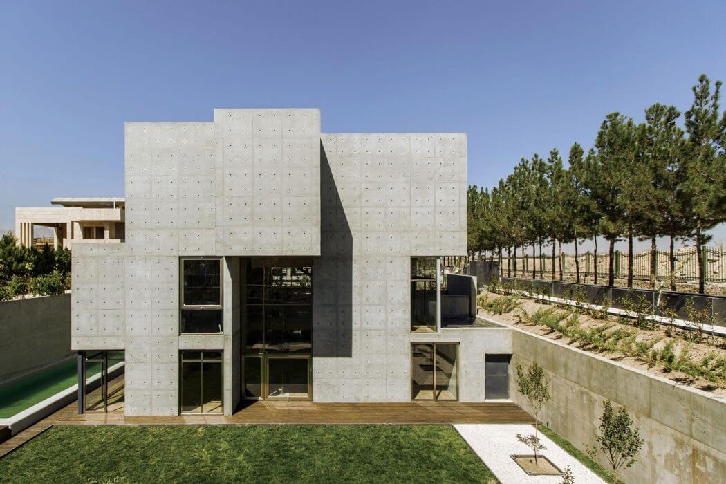 Impressive modern concrete building with clean geometric shapes and large windows.