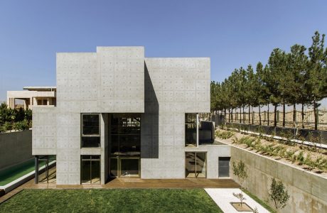 Impressive modern concrete building with clean geometric shapes and large windows.