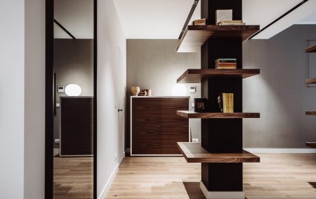 Sleek, modern interior design with dark wood shelving, minimalist furnishings, and natural lighting.