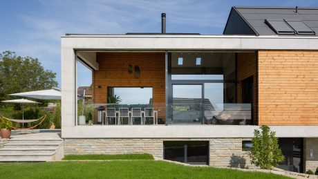 Modern, open-plan architecture with wood, stone, and glass elements; inviting outdoor space.