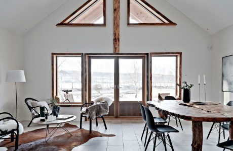 Rustic interior with wooden beams, large windows, and a cozy seating arrangement.