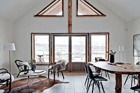 Rustic interior with wooden beams, large windows, and a cozy seating arrangement.