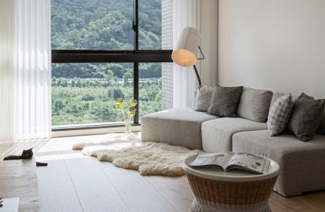 Spacious living room with large windows, cozy sofa, and minimalist decor showcasing the scenic landscape.