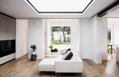 Bright and airy living room with sleek modern furniture, large windows, and natural wood flooring.