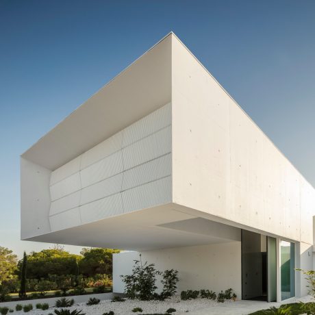 A modern, angular architectural design featuring a prominent cantilever and clean, minimalist lines.