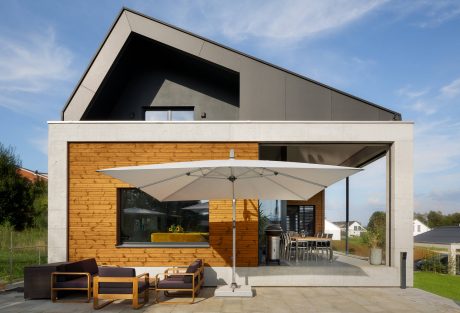 Sleek, angular modern home with wooden accents, open patio, and contemporary furnishings.