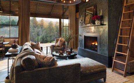 Cozy mountain retreat with rustic wooden beams, plush furnishings, and a roaring fireplace.